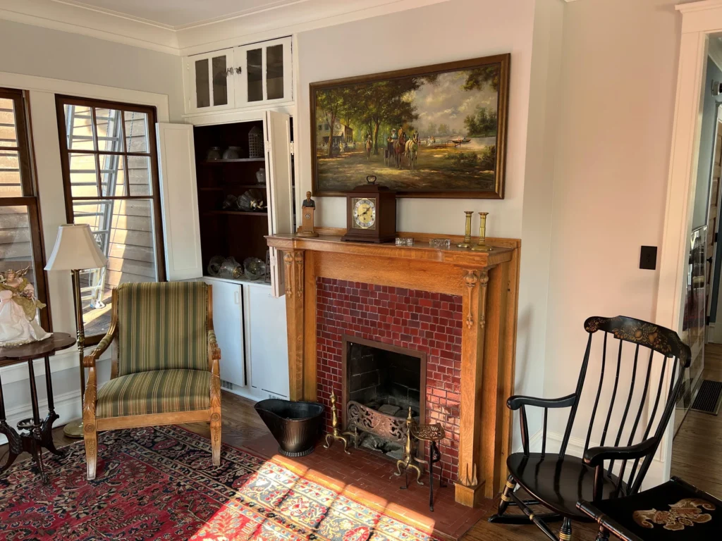 Restored Fireside Room Restored fireplace room with period chairs, rug, and built-in shelving.