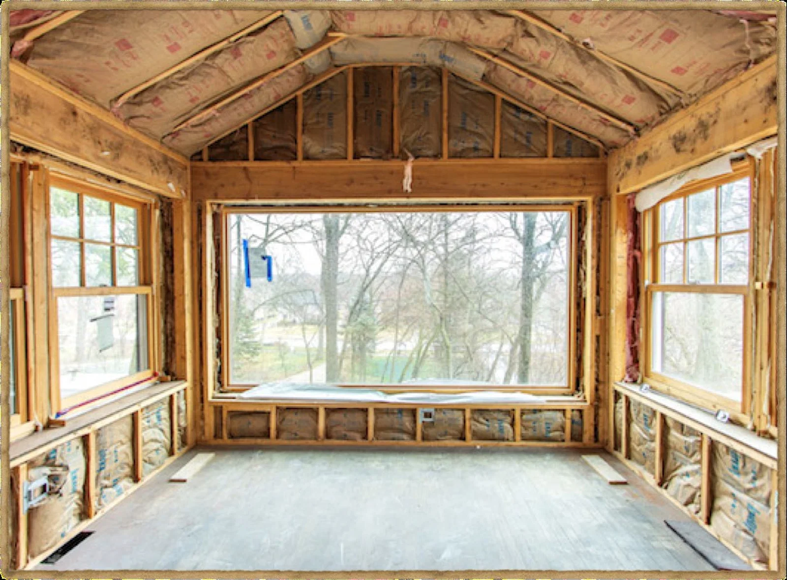 Front sun porch with exposed wall and roof framing during restoration.