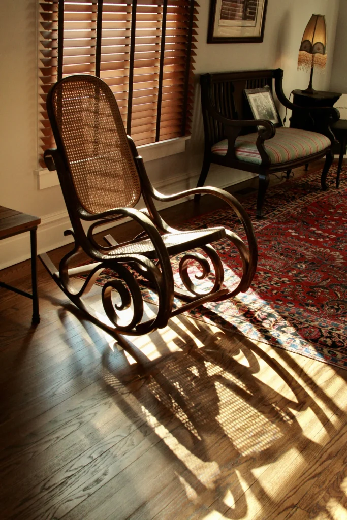 Historic Rocking Chair Wood rocking chair casting a long shadow across the floor of a restored room.