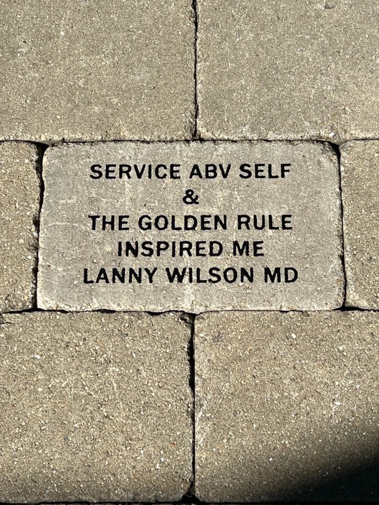 Inspirational Patio Brick Engraved brick reading “Service Above Self / The Golden Rule / Inspired Me / Lanny Wilson MD.”