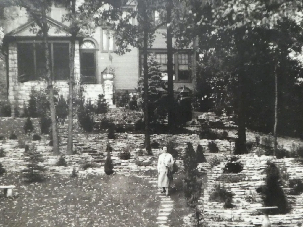 International Friendship Garden Historic view of the Harris Home garden with paths, plants, and a person standing among the plantings.