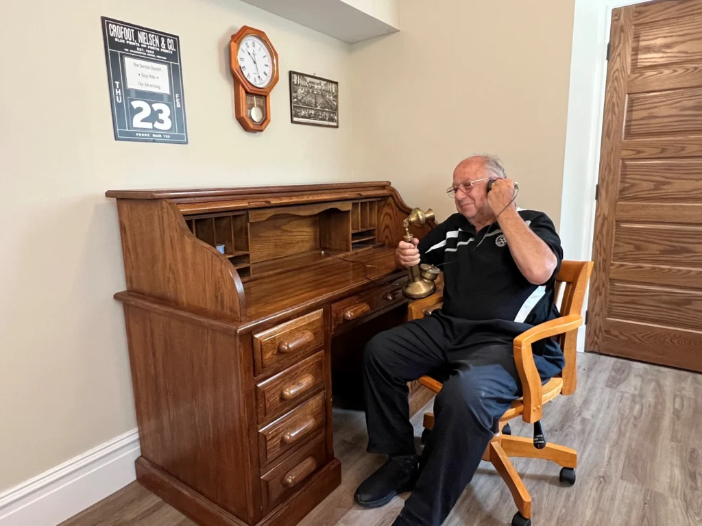 Irv Kaplan at PJHH District Office, 2023 Irv Kaplan seated beside a cabinet in an office or meeting space.