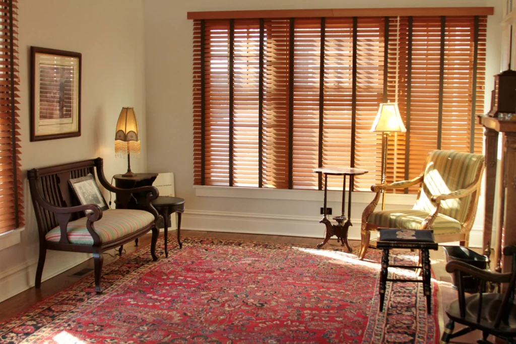 Restored Sitting Room Restored sitting room with period furniture, wood blinds, and an area rug.